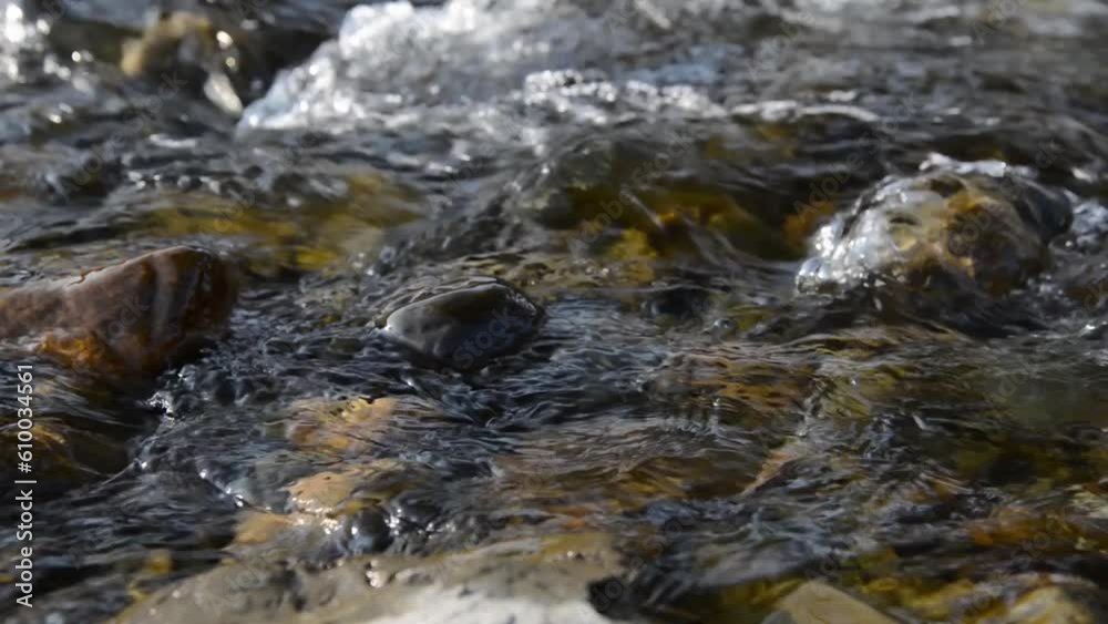 Motorised dolly slider shot of the splashing water in a small mountain river near forest. Huge wet rocks and sun rays. Horizontal steady movement at rural scene. Raw flat colors. Motorised dolly slider shot of the splashing water in a small mountain river near forest. Huge wet rocks and sun rays. Horizontal steady movement at rural scene. Raw flat colors.