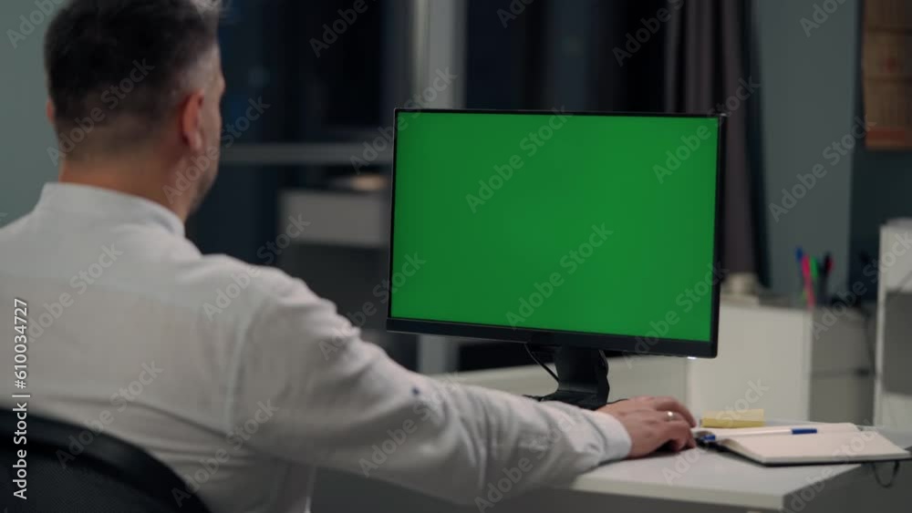 Man Working At Computer With Green Mock Up Screen in Home. Close Up Desktop Computer Monitor with Mock Up Green Screen Chroma Key Display Man Working At Computer With Green Mock Up Screen in Home. Close Up Desktop Computer Monitor with Mock Up Green Screen Chroma Key Display