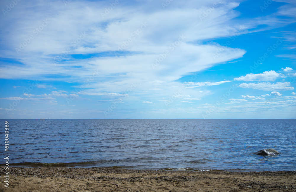 The Gulf of Finland in summer.White clouds over the water in summer.The horizon line above the waves.