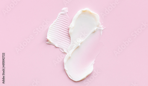 Swatch of white cream texture, cosmetics for face and body on a isolated light pink background