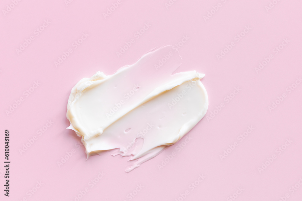 Swatch of white cream texture, cosmetics for face and body on a isolated light pink background. Smear. Swatch of white cream texture, cosmetics for face and body on a isolated light pink background. Smear.