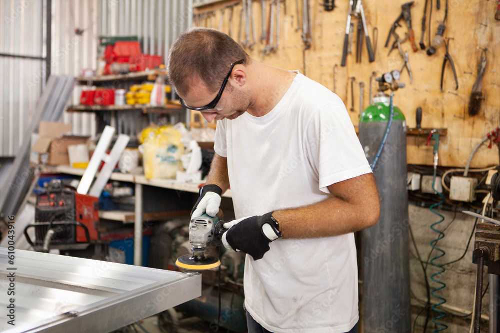 In a workshop, a skilled craftsman meticulously grinds a metal plate, shaping it with precision and expertise.