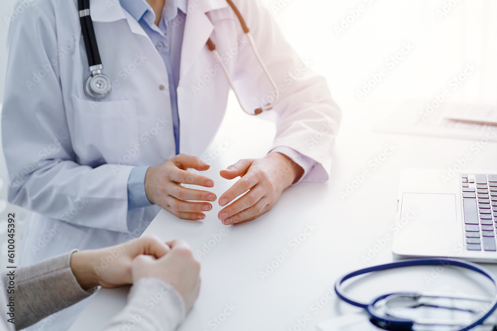 Doctor and patient discussing current health questions while sitting at the table in clinic office, only hands closeup. Medicine concept. Doctor and patient discussing current health questions while sitting at the table in clinic office, only hands closeup. Medicine concept.
