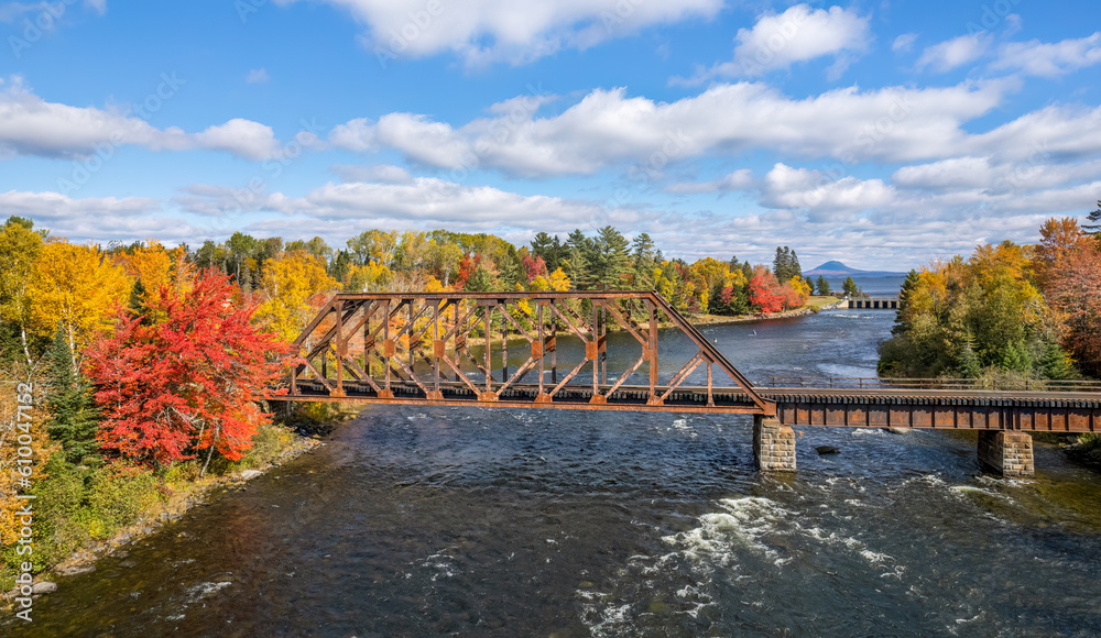 Autumn colors on the river at Moosehead Lake, Maine - train trestle