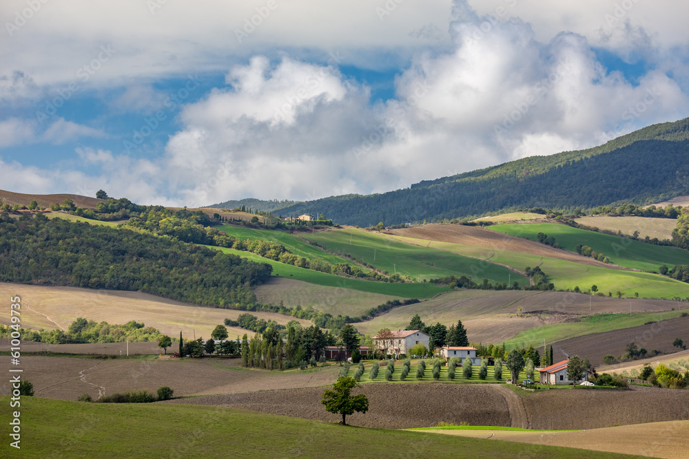 Obraz premium Beautiful landscape of the hills and mountains, Tuscany in the autumn with puffy clouds, travel perspective from the magical region of Italy