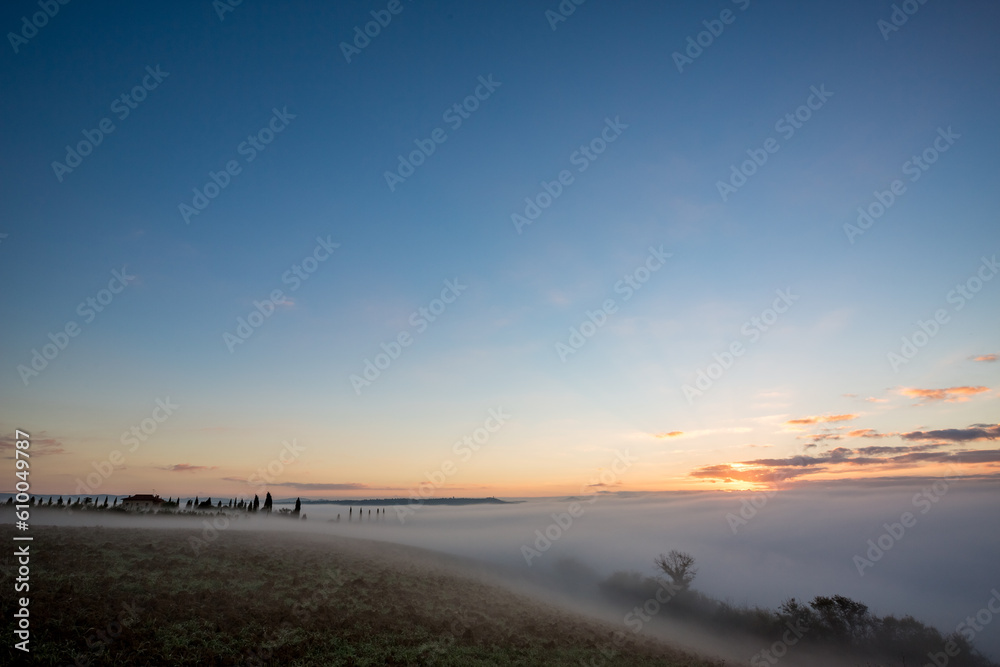 Thick morning fog over valleys, countryside Tuscany, Italy
