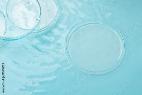 Set of laboratory utensils empty Petri dish, flasks, jars on the background of blue water