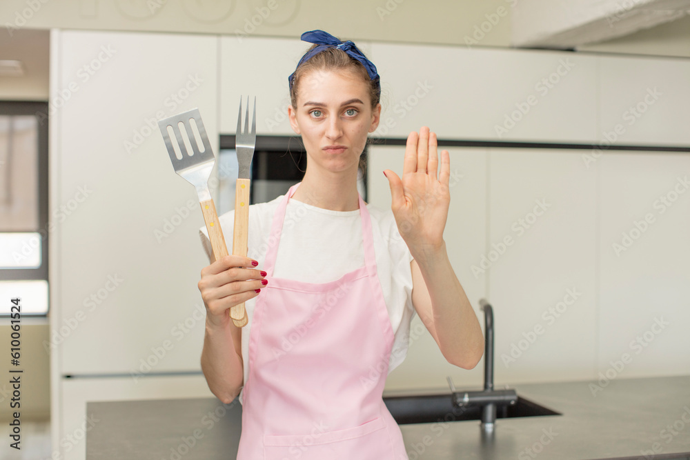 looking serious showing open palm making stop gesture. Barbecue tools concept looking serious showing open palm making stop gesture. Barbecue tools concept