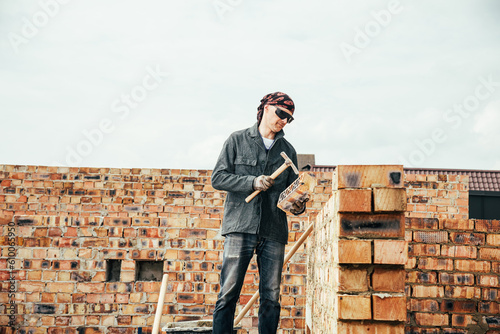 An experienced worker works on the construction of a brick house © Дмитро Петрина
