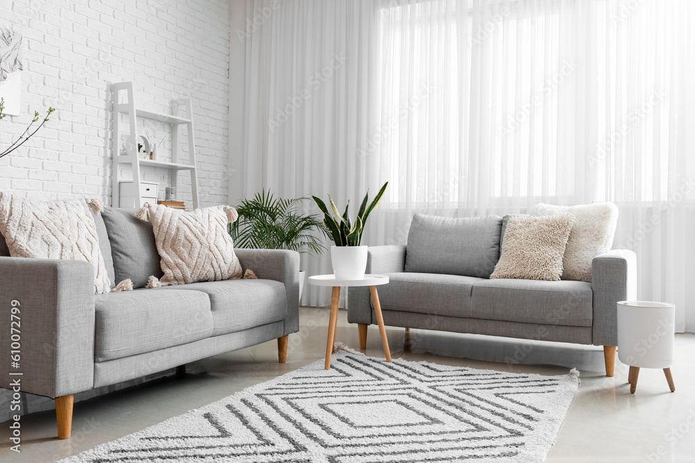 Fototapeta premium Stylish interior of light living room with comfortable sofas
