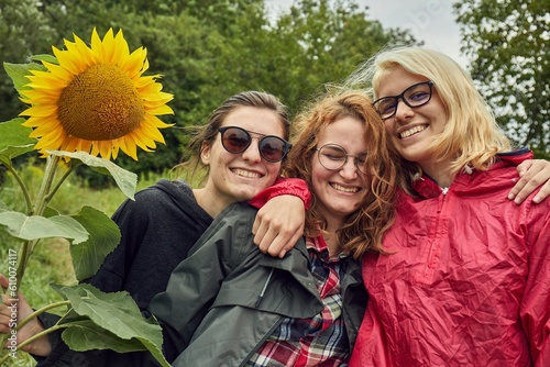 Girls making group photo holding sunflower photo