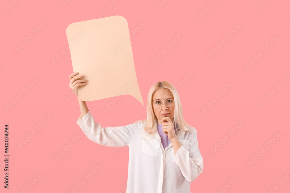 Thoughtful mature woman with blank speech bubble on pink background Thoughtful mature woman with blank speech bubble on pink background