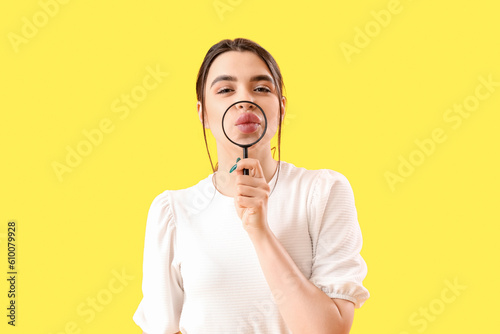 Young woman with magnifier ...