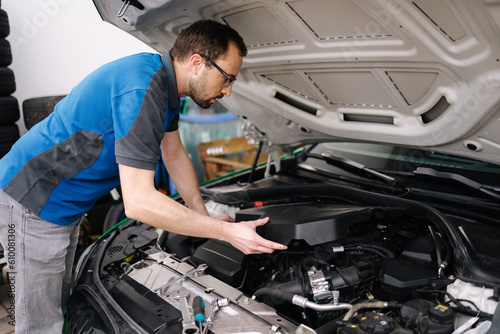 Auto mechanic working in garage. Open hood and start working. Repair service concept