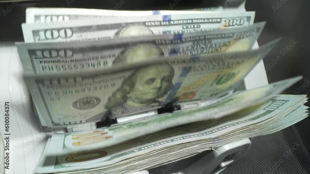 Close up of currency counting machine counting dollar bills. Banknote counter. Money counter with dollar bills. Money counter machine is counting American hundred dollars banknotes.