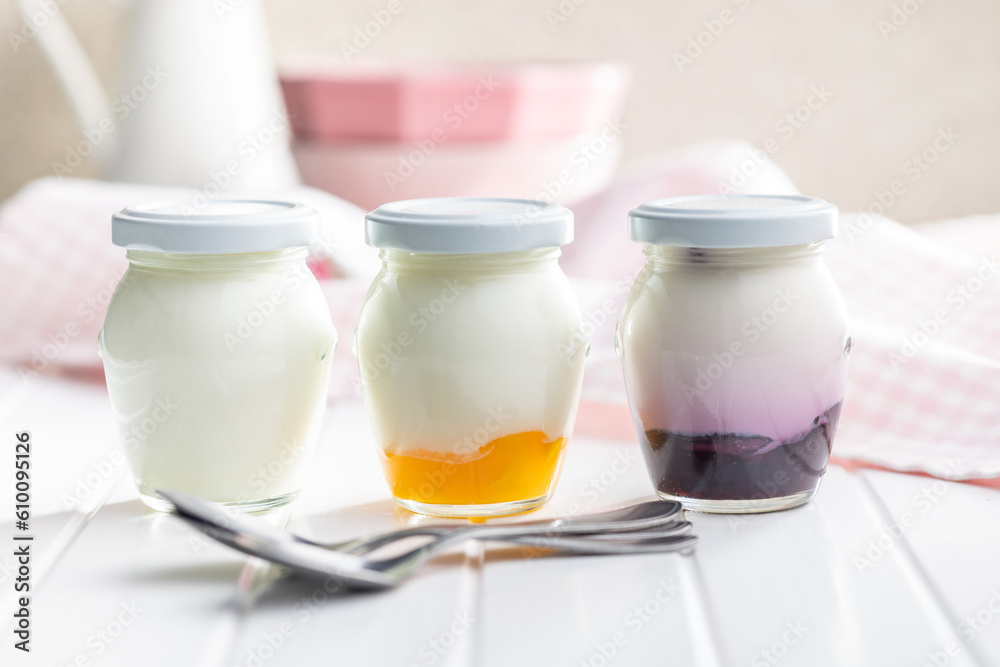 White and fruity yogurt in jar on white table. White and fruity yogurt in jar on white table.