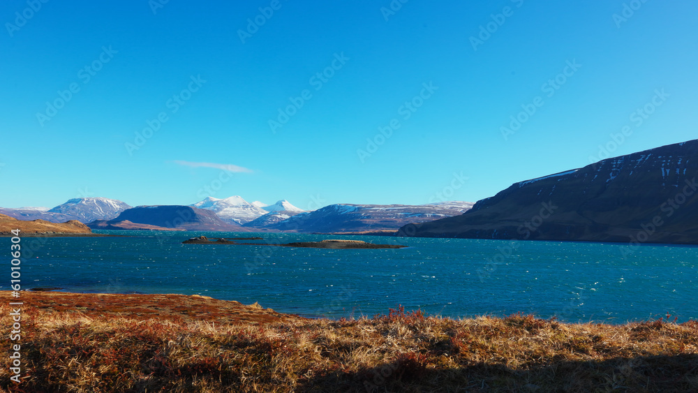 Fantastic lake and snowy mountain tops in iceland, spectacular icelandic nature and landscape. Huge water spot with mountains and hills creating panoramic view, arctic scenery. Handheld shot.