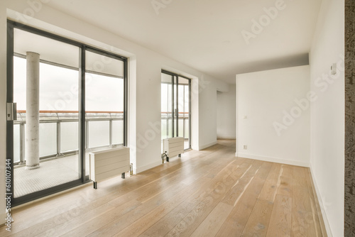 an empty living room with wood flooring and sliding glass doors looking out onto the water view from the balcony