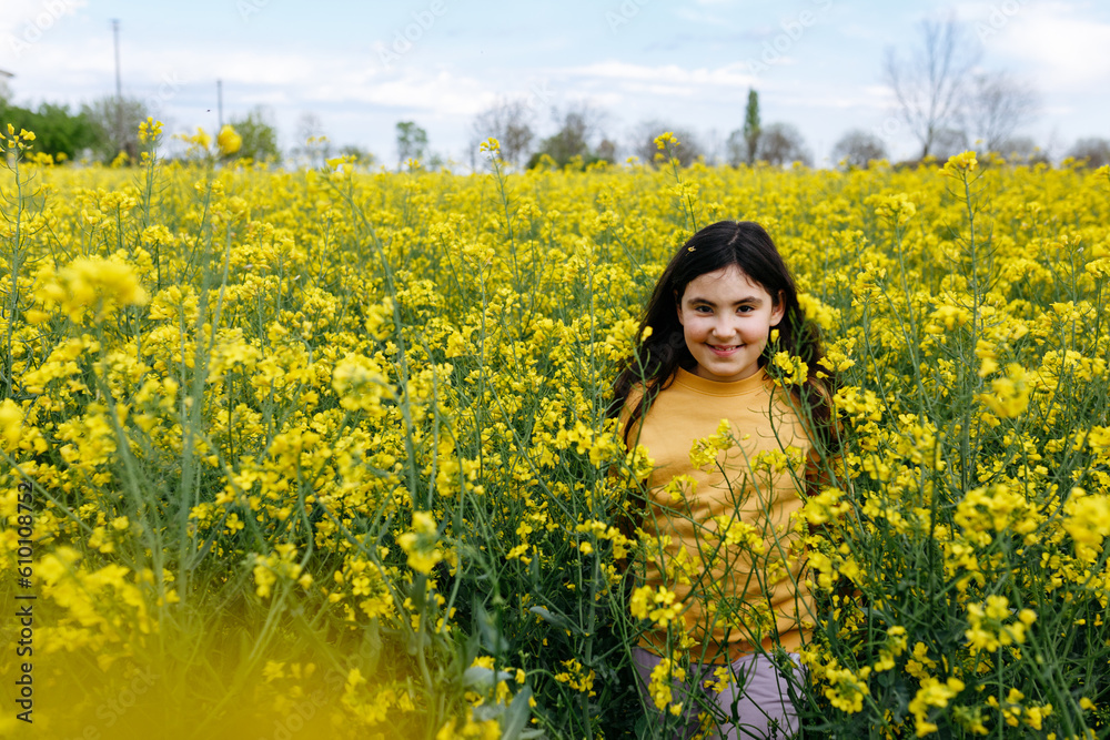 running smiling girl with long hair in the field with yellow flowers running smiling girl with long hair in the field with yellow flowers