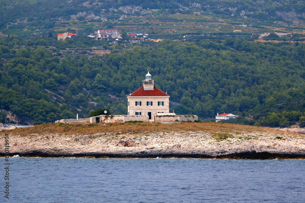 Picturesque stone lighthouse on a tiny island near Hvar, Croatia.