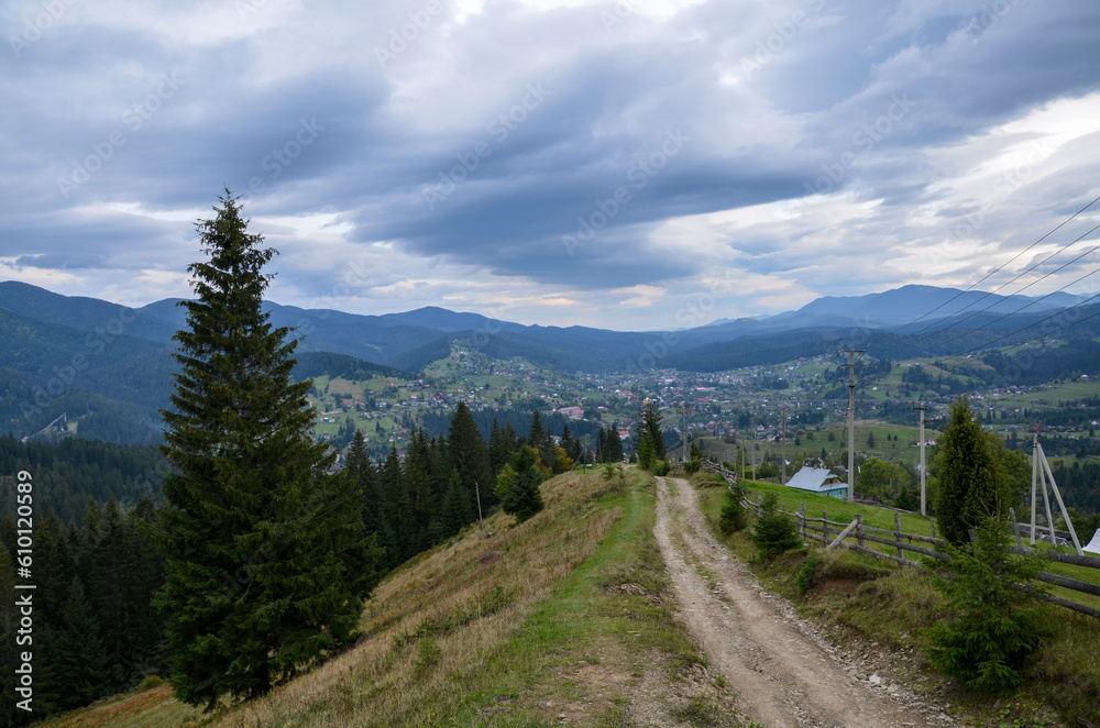Beautiful landscape with forested hills and Carpathian village in the valley. Carpathian mountains in summer