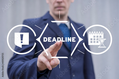 Businessman using virtual touch screen presses text: DEADLINE. Concept of deadline for time slipping away for important appointment date, schedule. Time management and business planning.