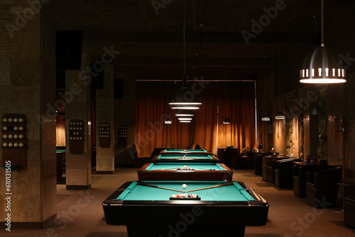 Billiard tables with balls and cues in club