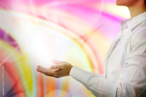 Aura phenomena. Woman with flows of energy coming out from her hands against color background, closeup