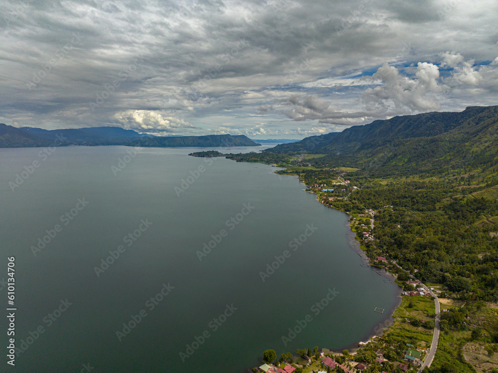 Lake Toba and the island of Samosir with houses on the shore view from above. Sumatra, Indonesia.