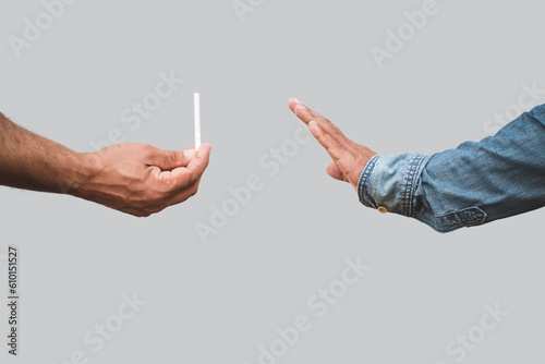 Man's hand holding a cigarette and passed to hand show signs of decline. Concept for no smoking.