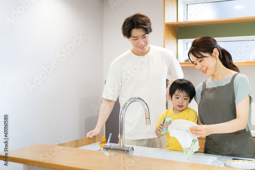 Family members washing dishes in the kitchen on good terms.