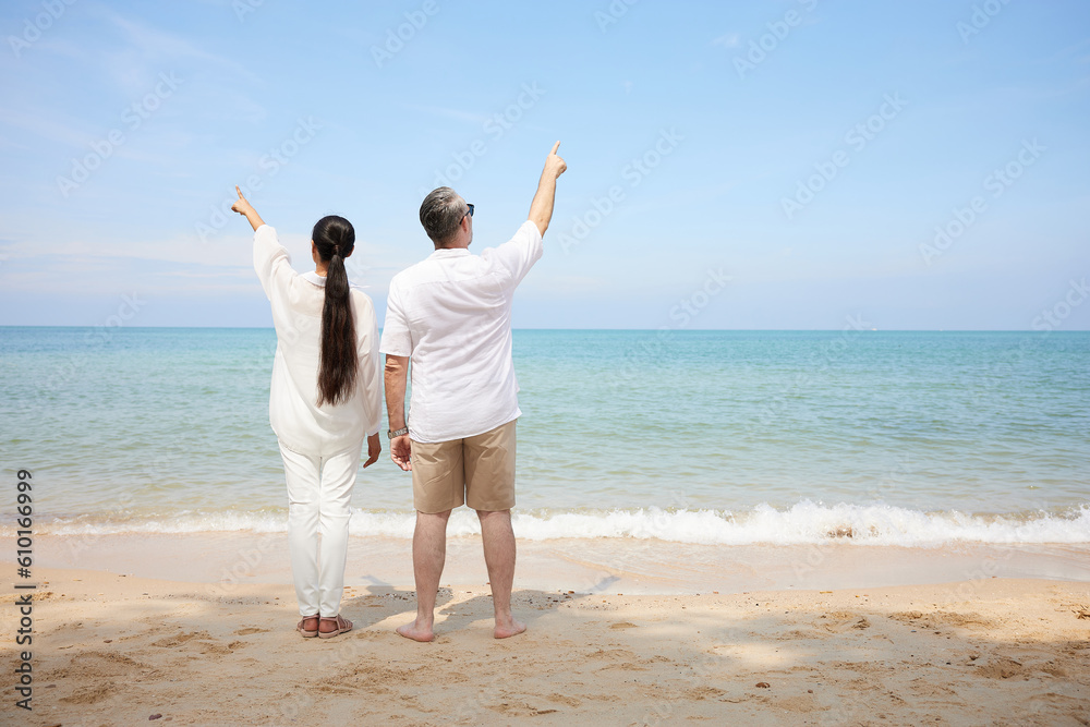 back couple pointing and looking to sky on the sea back couple pointing and looking to sky on the sea