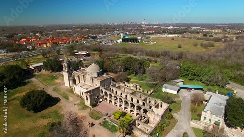 Aerial Shot Of Mission San Jose Church Against Blue Sky, Drone Ascending Backward Over City On Sunny Day - San Antonio, Texas photo