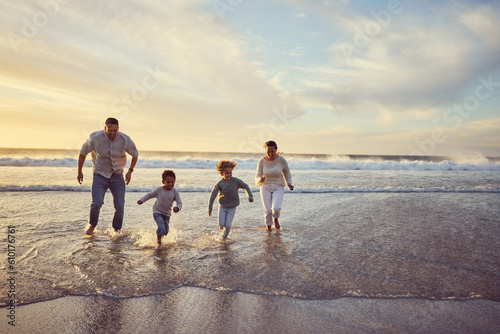 Beach, sunset and parents run with children on holiday, summer vacation and weekend together. Nature, travel and happy mother, father and kids play in ocean for bonding, adventure and family time