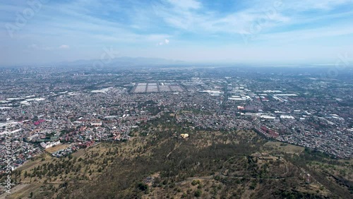 backwards drone shot of east Mexico city over cerro de la estrella in iztapalapa photo