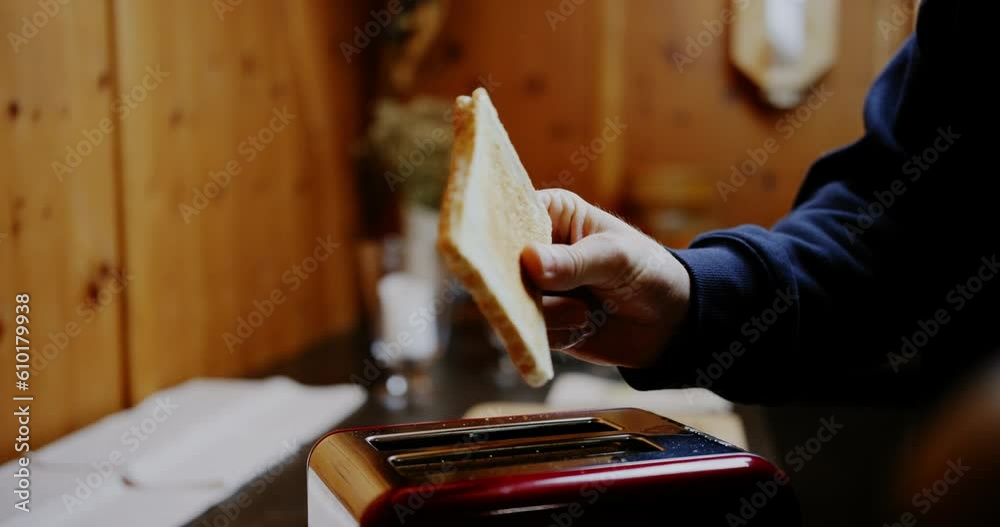 Hand catches perfectly brown toasted white bread popping up out of