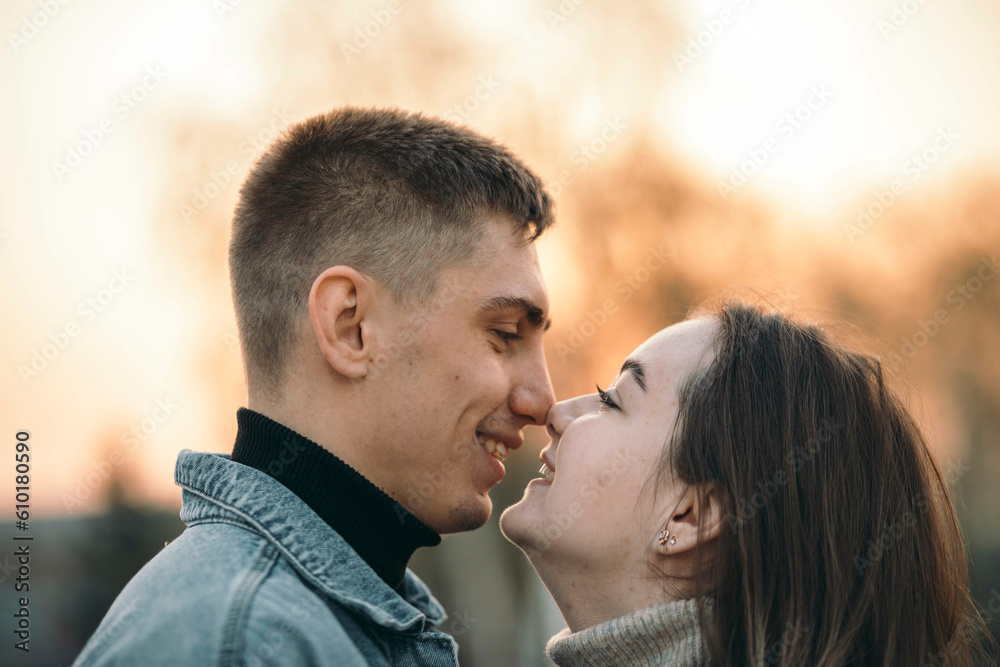 Close up of a smiling beautiful young couple in park at the sunset, happy lifestyle concept Close up of a smiling beautiful young couple in park at the sunset, happy lifestyle concept