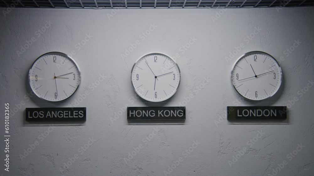 Walking wall clocks illuminated by LED lamp in office with modern