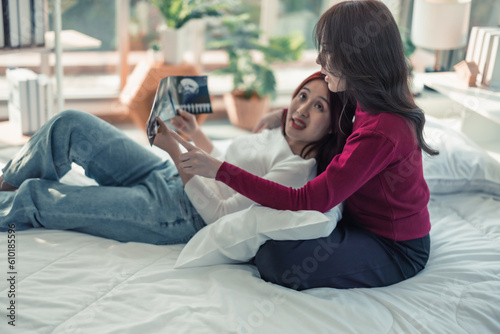 Lesbian couples feel happy, glad, excited when they get ultrasound images of their baby's gender, health, and progress in the mother's womb. Surrogacy of infertility families in modern LGBT families.