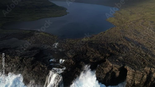 Fantastic aerial shot over the SØRVÁGSVATN lake and the beautiful waterfall that is found is gradually being discovered. In the Faroe Islands and during sunset. photo