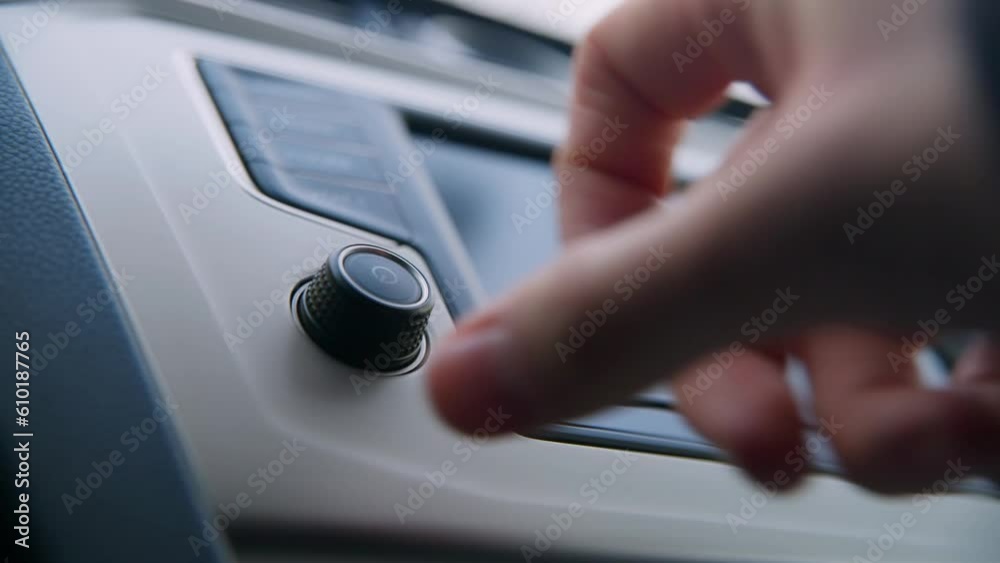 Adjusting radio volume with a button on car dashboard Adjusting radio volume with a button on car dashboard