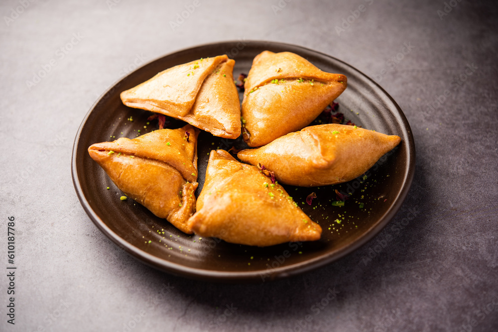 Indian sweet samosa is a Fried pastry soaked in sugar syrup filled with coconut, nuts and fruits Indian sweet samosa is a Fried pastry soaked in sugar syrup filled with coconut, nuts and fruits