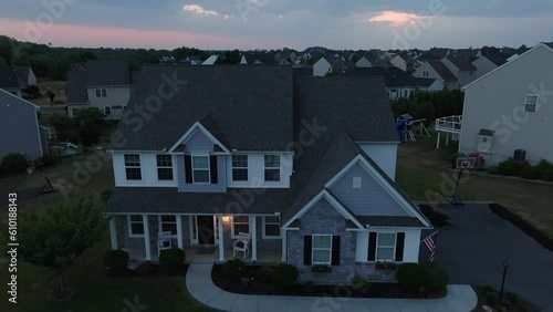 Wallpaper Mural USA home at night with American flag and house lights on. Aerial descending shot of upscale housing in neighborhood in America at night. Torontodigital.ca