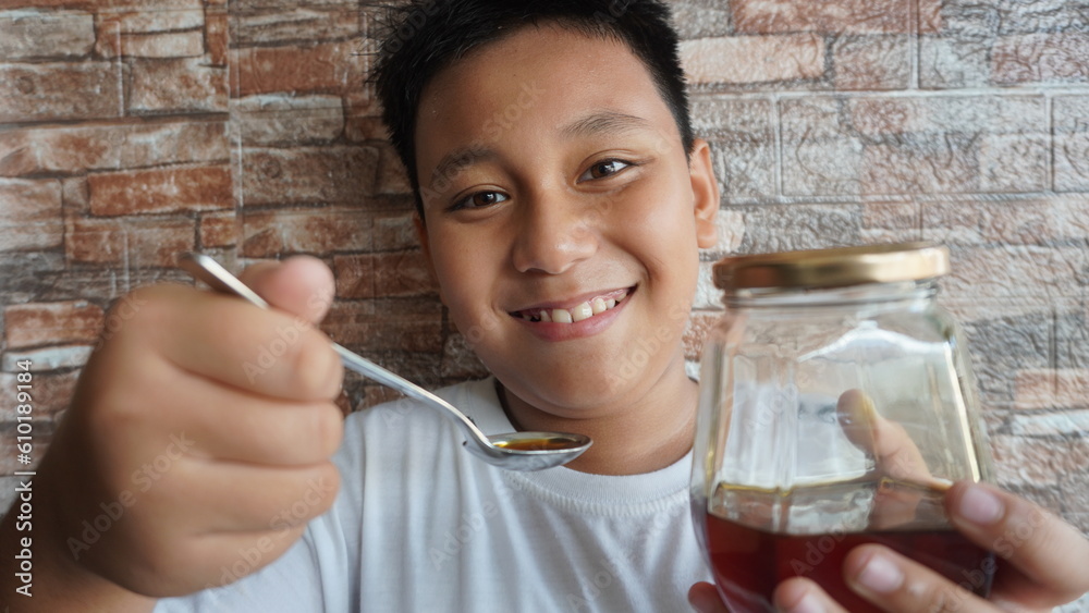 Selective focus close up portrait boy is holding a spoon and puts it in his mouth. male expression when eating Selective focus close up portrait boy is holding a spoon and puts it in his mouth. male expression when eating