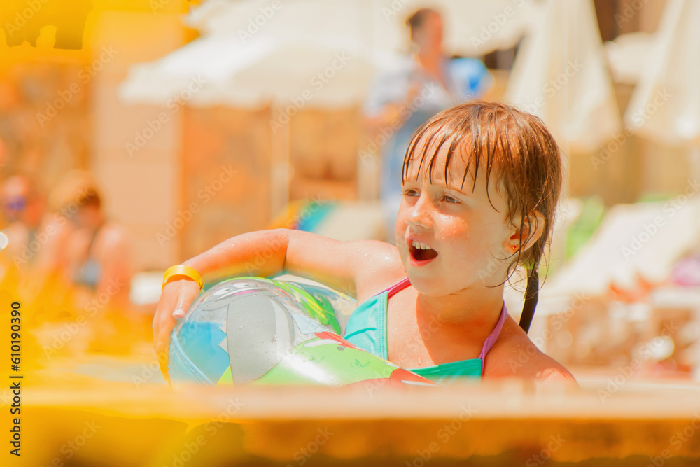 Funny portrait of cute little child girl having fun with water in the swimming pool. Summer holiday, adventure and happy childhood.