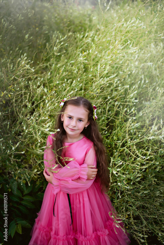 Little girl in pink dress look at camera