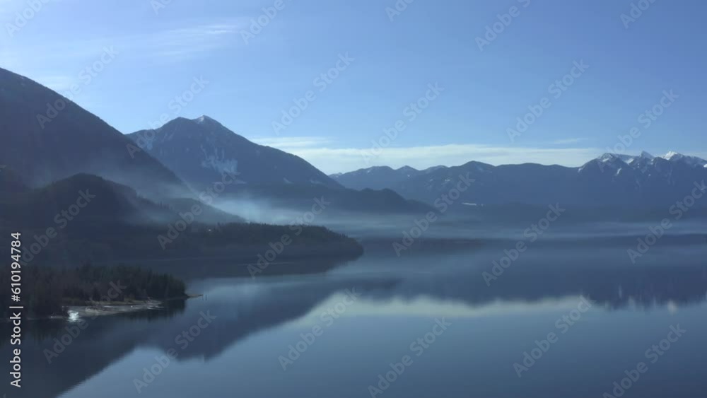 Reflective Whispers: Capturing Smoke's Mystique on Slocan Lake's Mirrored Surface Reflective Whispers: Capturing Smoke's Mystique on Slocan Lake's Mirrored Surface