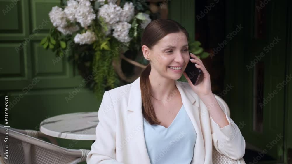 Beautiful young woman talking on phone at outdoor cafe Beautiful young woman talking on phone at outdoor cafe
