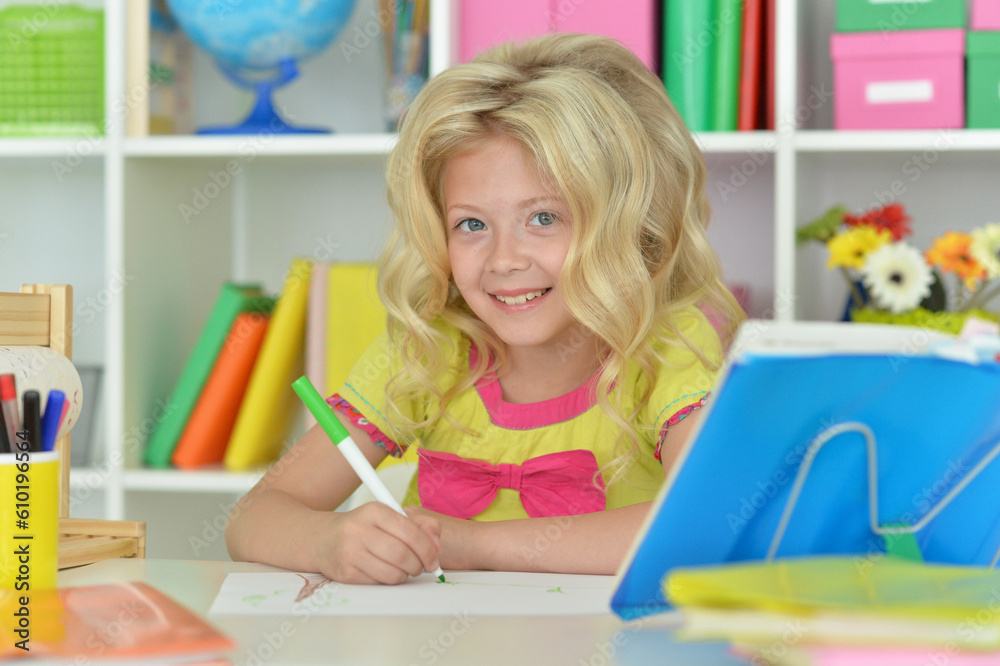 little girl studying at home at the table
