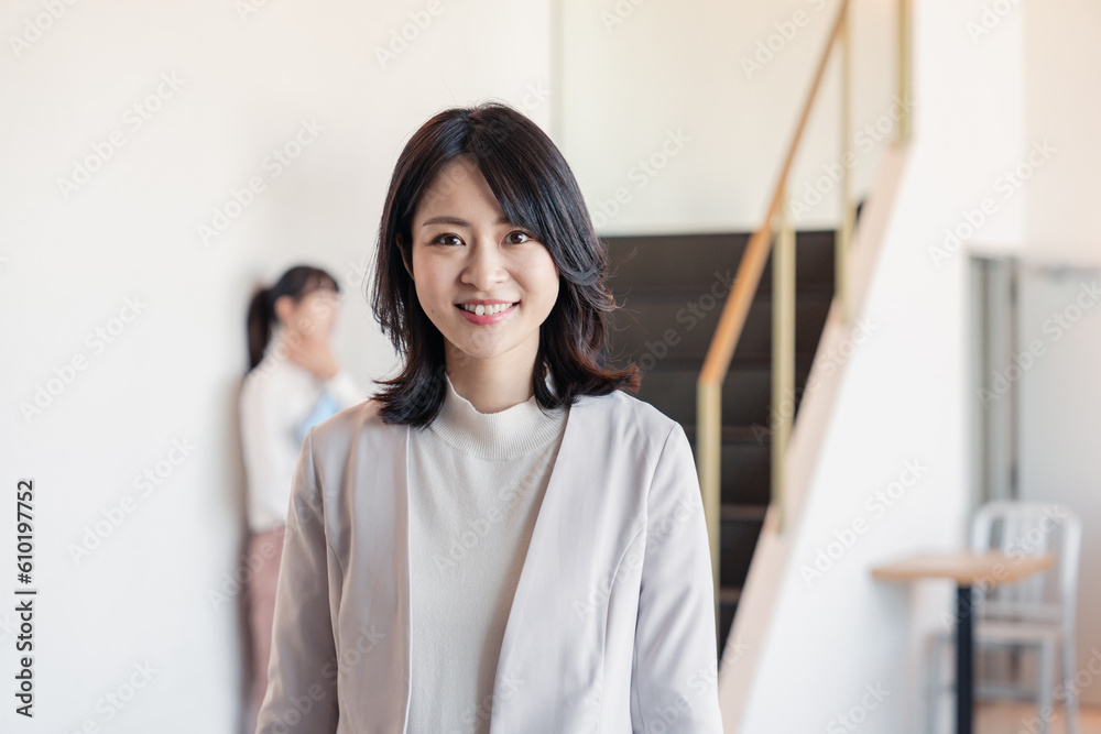 笑顔でオフィスを歩く女性経営者